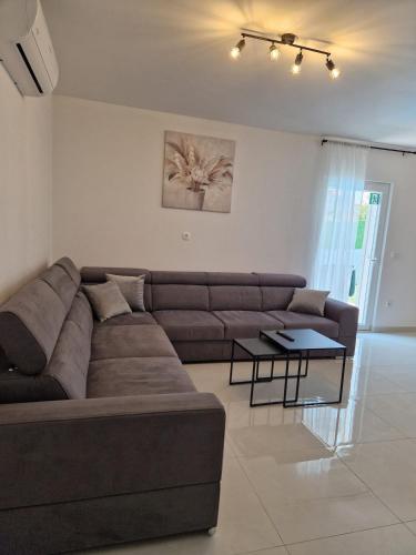 a living room with a brown couch and a table at Apartman Mista in Solin