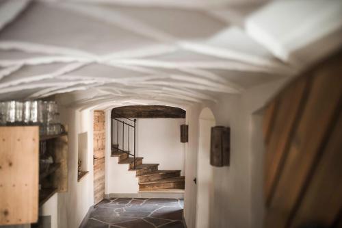 a hallway with a white ceiling and stairs in a building at Huberhof in Fiè