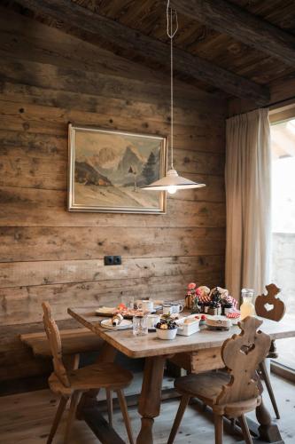 a wooden dining room with a wooden table and chairs at Huberhof in Fiè