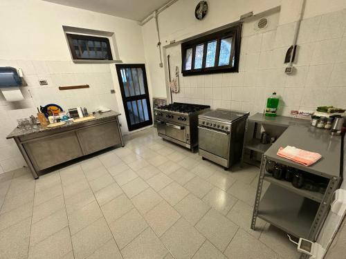 a large kitchen with stainless steel appliances and tile floors at Studio Della Fiamma in Gubbio
