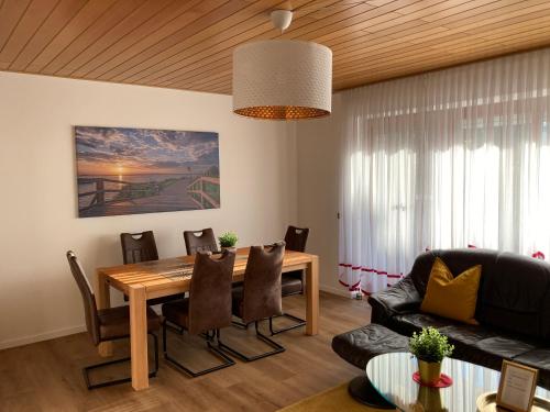 Un comedor con mesa y sillas de madera. en Apartment Meertraum Steinhude, en Steinhude
