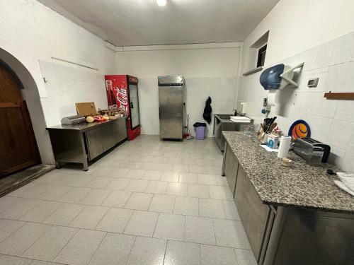 a large kitchen with a refrigerator and a tile floor at Studio Della Fiamma in Gubbio