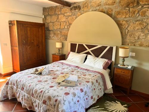 a bedroom with a bed with a stone wall at Cottage Apanu in Viterbo