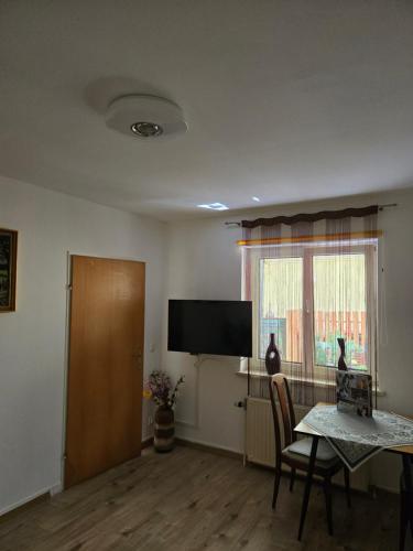 a living room with a table and a flat screen tv at Appartement Purzel in Mauerbach