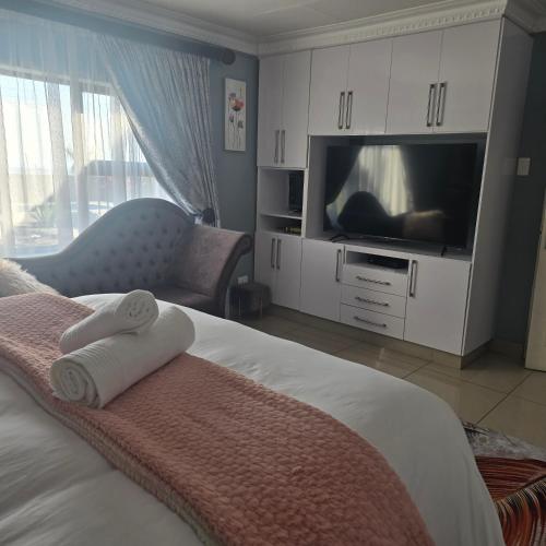 a bedroom with a bed with a tv and towels at Cosy Villa in Stegi