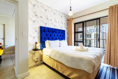 ミッドラントにあるAlimamaSpaces The Munyakas Manson 1543のベッドルーム1室(大型ベッド1台、青いヘッドボード付)