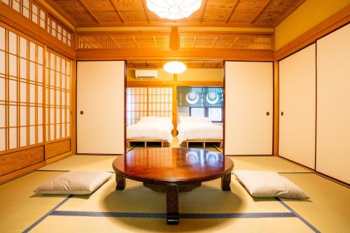a room with a table and two beds at Koyasan Gokuraku Stay in Koyasan