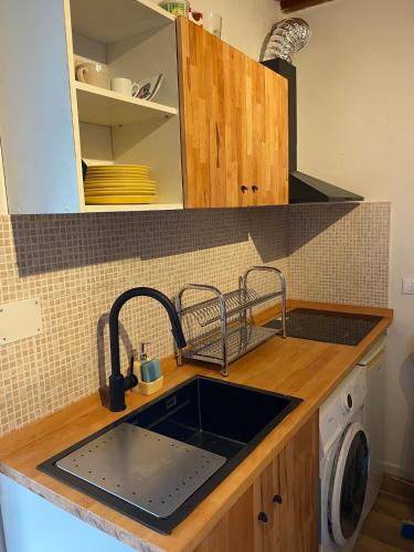 a kitchen with a sink and a washing machine at Rustichello G&P Tuscany in Lorenzana