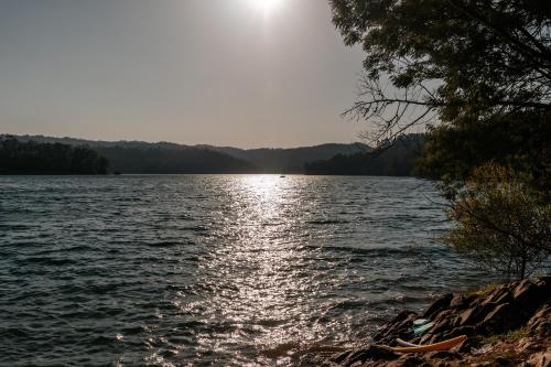 a view of a lake with the sun reflecting on the water at Alma-Rio Room 3 by Mycelia in Tomar