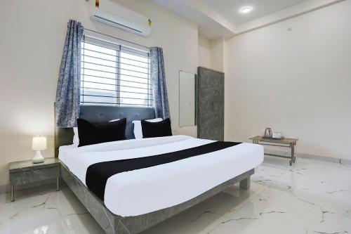 a large bed in a room with a large window at Hotel O Grand Embassy in Mānglia