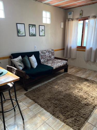 a living room with a blue couch and a rug at Ótima casa de praia a 2 quadras do mar in Tramandaí