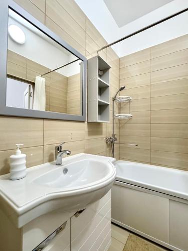 a bathroom with a sink and a tub and a mirror at Station Hostel in Atyrau