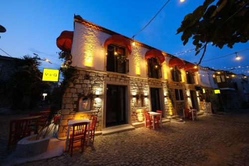 a stone building with tables and chairs outside at night at VoQ Alaçatı Hotel in Çeşme