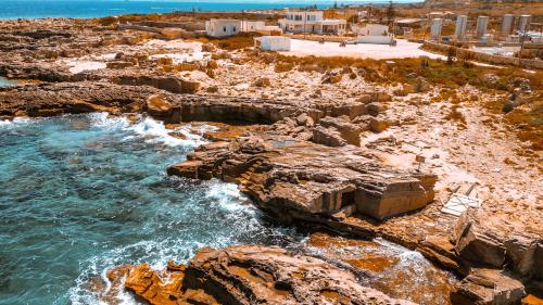 an aerial view of a beach with rocks and the ocean at Dimora Cala Graziosa in Favignana