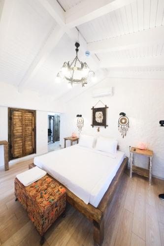 a bedroom with a large bed and a chandelier at VoQ Alaçatı Hotel in Çeşme