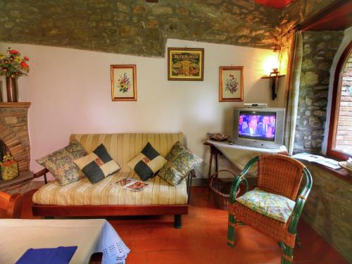 ein Wohnzimmer mit Sofa und Fernseher in der Unterkunft Farmhouse in Cortona in Cortona