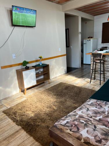 a living room with a tv on a wall at Ótima casa de praia a 2 quadras do mar in Tramandaí