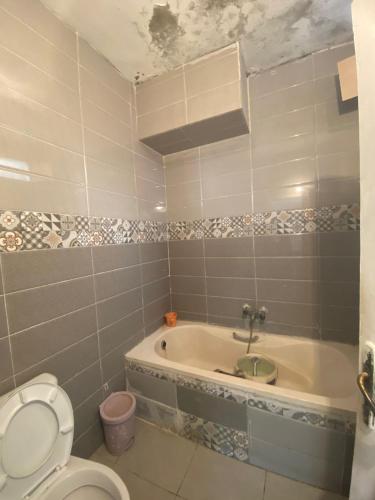 a bathroom with a toilet and a bath tub at vacation house s2 80 dt nuitée in Kelibia
