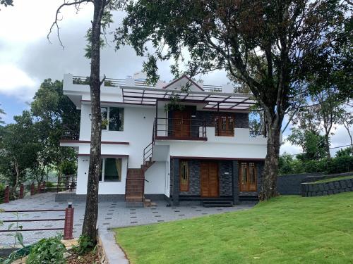 バガモンにあるGREENSHORE 4BHK Villa Vagamonの目の前に木々が植えられた白い家