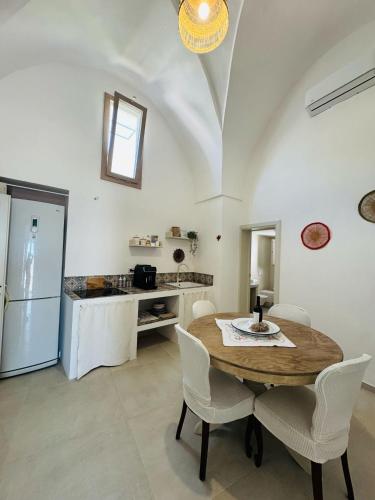 a kitchen with a table and chairs and a refrigerator at Relais Filomarino casa vacanze in Corsano