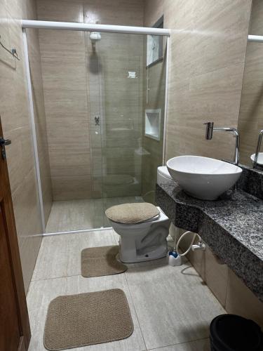 a bathroom with a shower and a toilet and a sink at Casa Barreirinhas Lençóis Maranhenses in Barreirinhas
