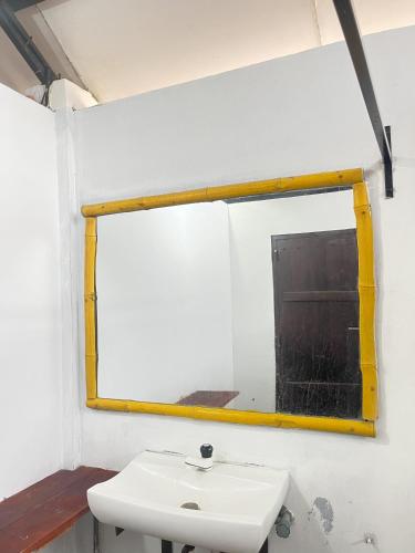 a mirror above a white sink in a room at Wild Hostel Wilpattu in Achchamulai