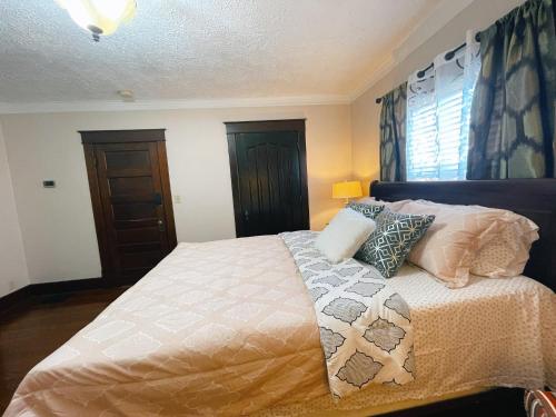 a bedroom with a bed with pillows on it at Victorian Home in Original Grandeur Downtown in Kokomo