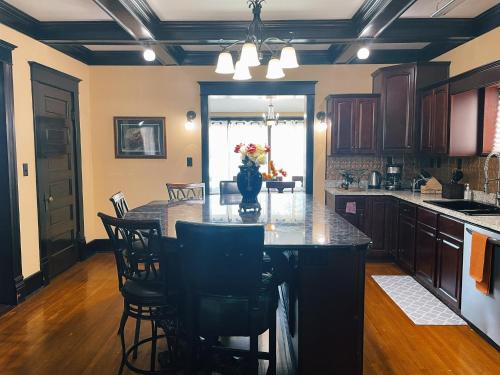 a kitchen with a large island with chairs around it at Victorian Home in Original Grandeur Downtown in Kokomo