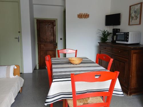 a dining room with a table with chairs and a microwave at Le Som' des Pyrénées in Luz-Saint-Sauveur
