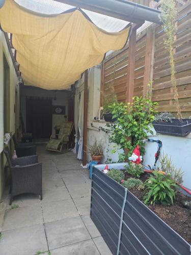 a patio with a yellow umbrella and some plants at Appartement Purzel in Mauerbach