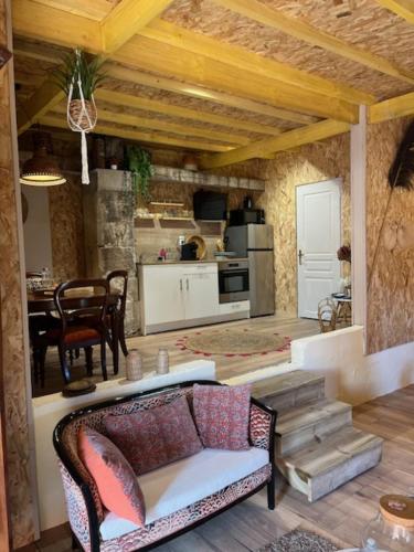 a living room with a couch and a kitchen at Le Mas Réolais in Saint-Sève