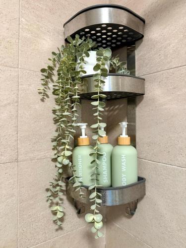 a wall with three soap bottles and a plant at Airy 1BR Pool and Beach Retreat in San Pedro de Macorís