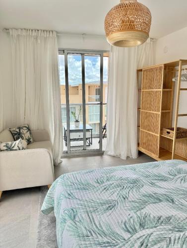 a bedroom with a bed and a couch at Airy 1BR Pool and Beach Retreat in San Pedro de Macorís