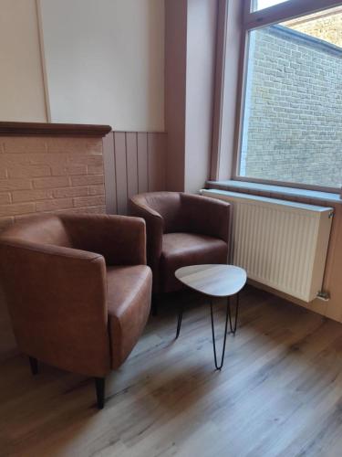 a waiting room with two chairs and a table at vakantiewoning 't Rijhuys in Diksmuide