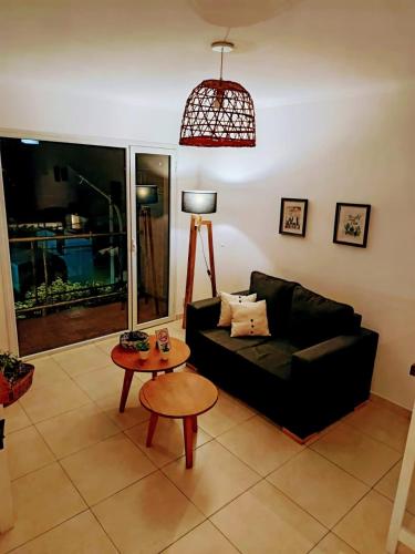 Una sala de estar con un sofá negro y una mesa. en Paloma Suites, en Tandil
