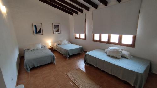 a bedroom with two beds in a room with windows at La Caseta de Rotova - Casa Rural para desconectar in Rótova