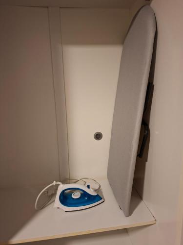 a white cabinet with a blue and white phone on it at Casa Alto Da Boa Vista Com Piscina e Churrasqueira in São Paulo