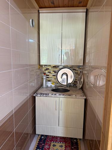 a small bathroom with a sink and a mirror at Konçoğlu Pansiyon in Uzungöl