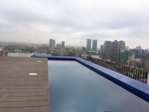a swimming pool on the roof of a building at Cozy, Elegant & Comfortable Apartment in Lima in Lima