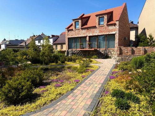 a brick house with a garden in front of it at Dom w centrum Tucholi in Tuchola