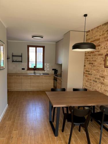 a kitchen and dining room with a wooden table and chairs at Dom w centrum Tucholi in Tuchola