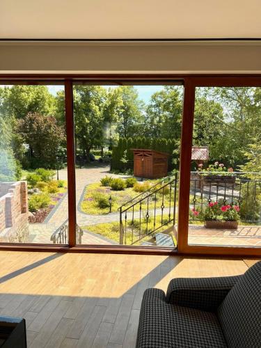 a room with a large window looking out at a garden at Dom w centrum Tucholi in Tuchola