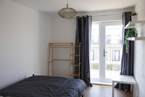 a bedroom with a bed and a large window at Top-Floor Penthouse with Panoramic Views in Romford