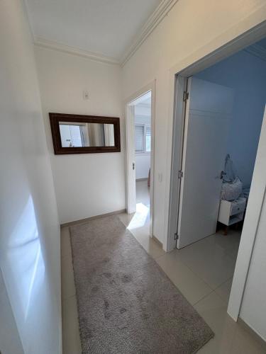 a room with a hallway with a mirror and a door at Carlos Hanauer in Osório