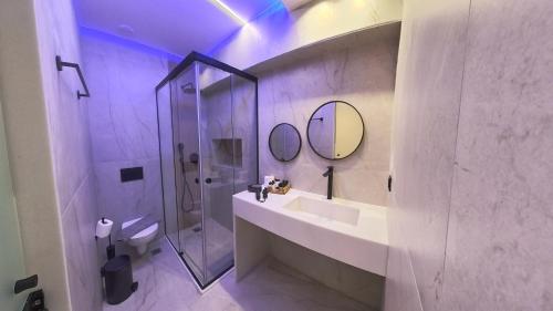 a bathroom with a shower and a sink and a mirror at AKTEON GIRNI in Paralia Katerinis