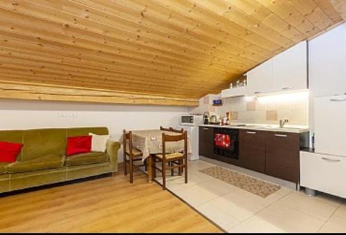 Una sala de estar con un sofá verde y una mesa. en Appartamenti Callori Karin, en Canazei
