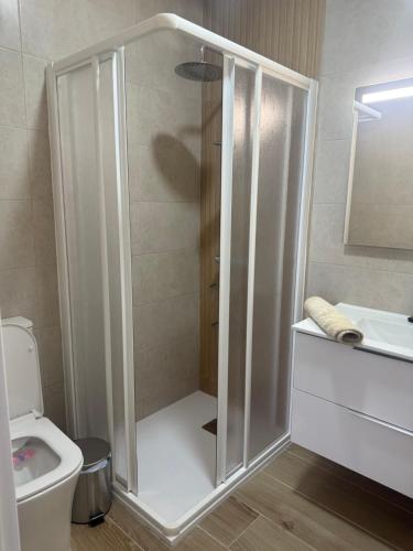 a bathroom with a shower with a toilet and a sink at Casitas mis niñas in Barbate