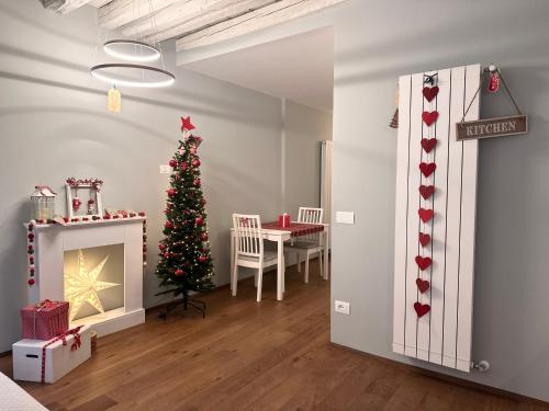 a living room with a christmas tree and a fireplace at Suite Apartment a tema Natale in centro storico "Gingerbread Suite" in Chioggia