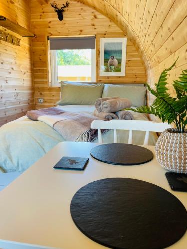 a bedroom with a bed and a table in a room at Crofters Coorie in Broadford