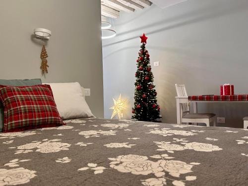 a christmas tree in a bedroom with a bed at Suite Apartment a tema Natale in centro storico "Gingerbread Suite" in Chioggia